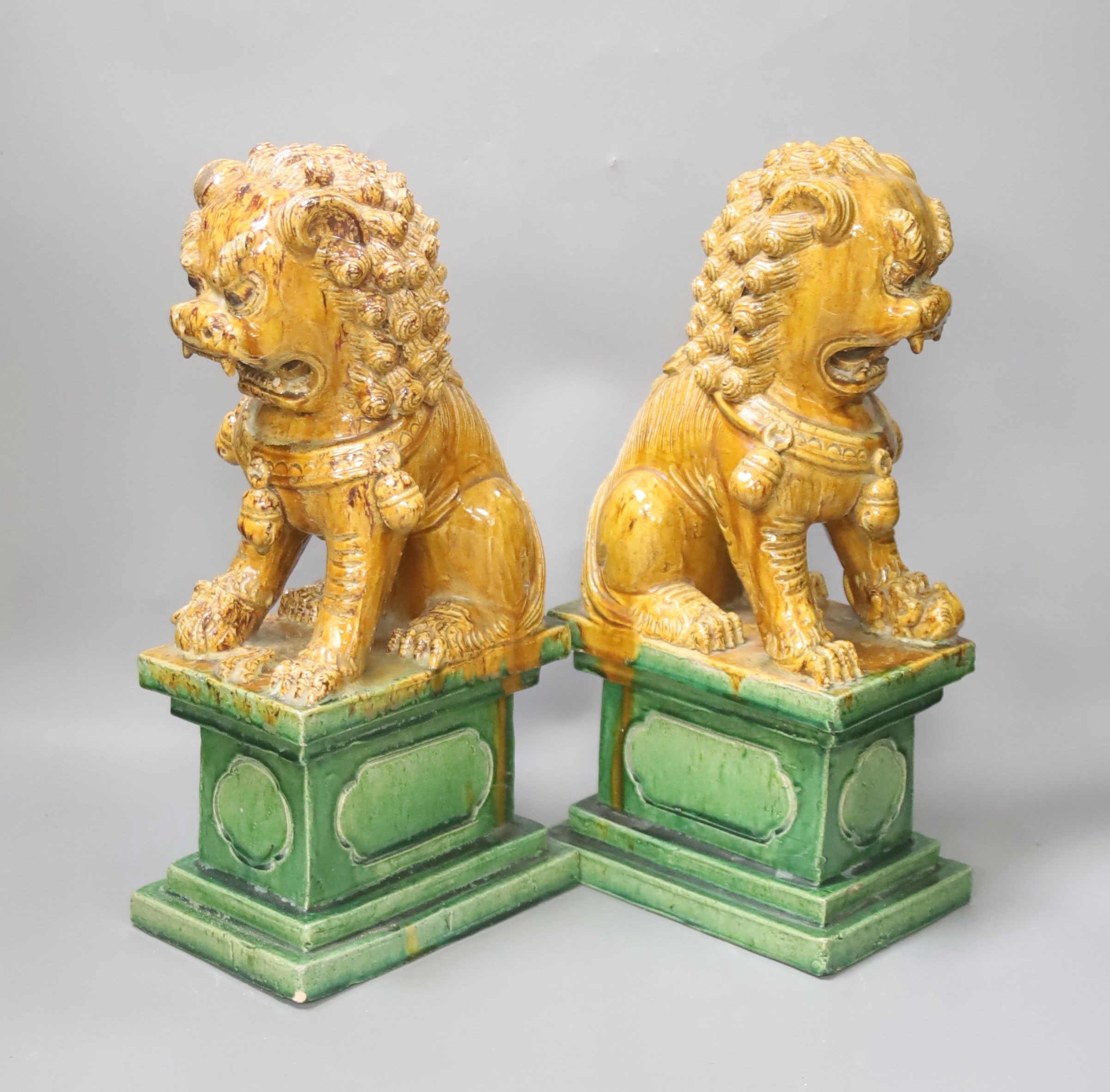 A pair of Chinese Ming style sancai-glazed pottery temple lions, H 35cm